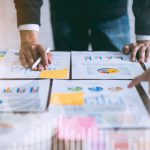 double exposure of business people meeting team working on wooden desk and hand man pointing to financial documents in office. successful meeting workplace strategy.